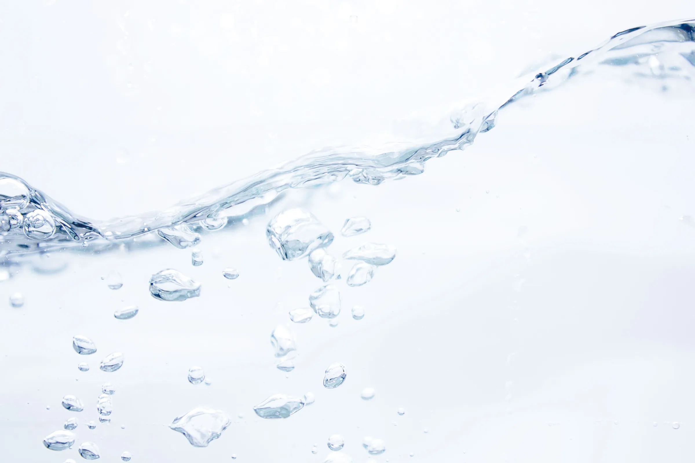 光を受けて広がる澄んだ水と泡
